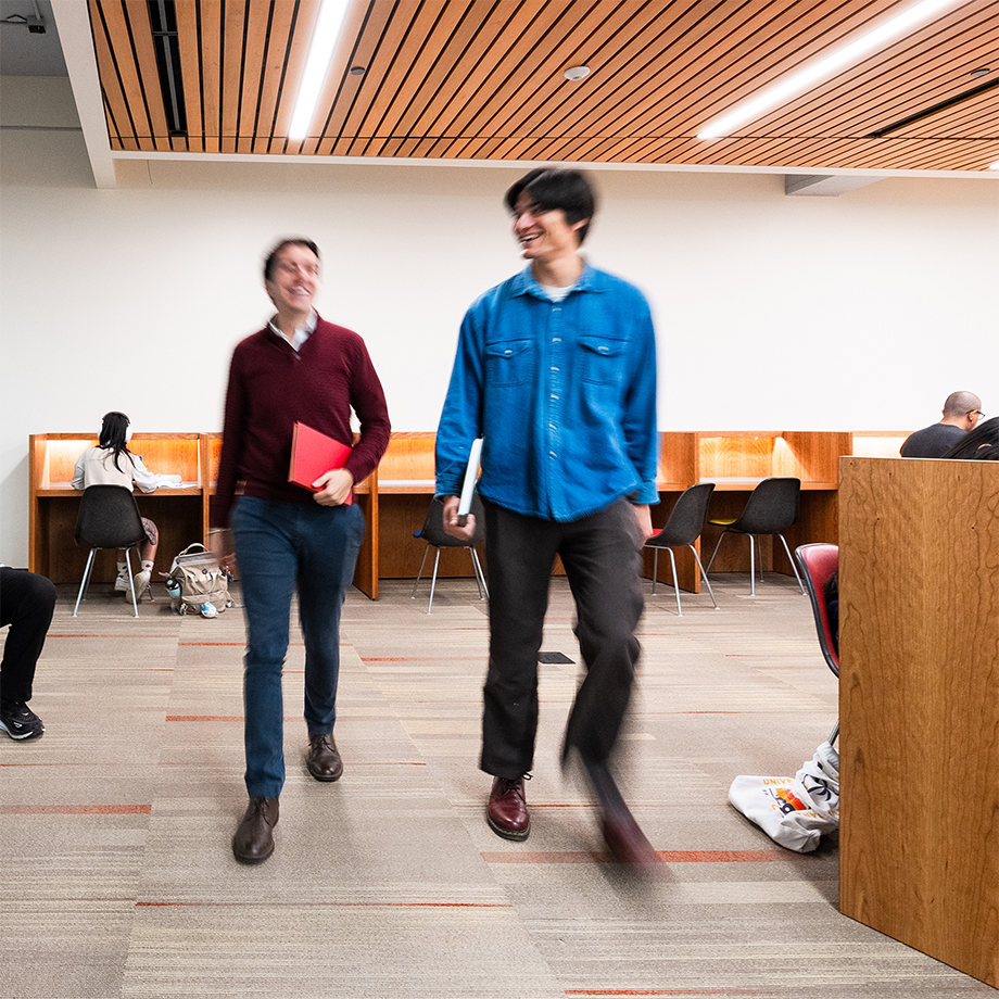 Two people walking in the Sara Miller McCune Arts Library