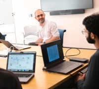 A professor sitting at a table with students